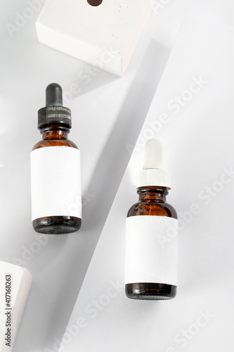 Close-up serum essence in glass bottle on white stand background. Isolated skincare oil