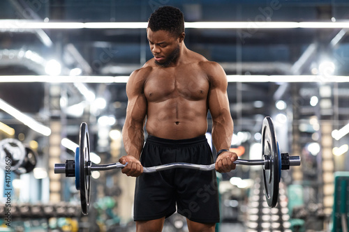 Athletic black man working on arms and chest musculs