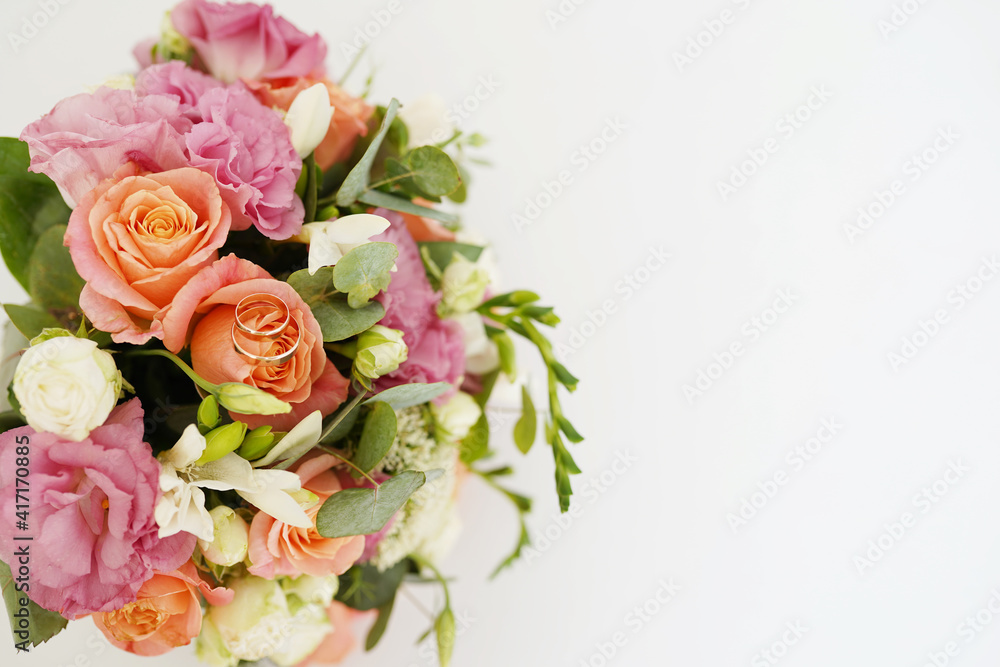 wedding Bouquet of flowers and golden rings isolated on white background