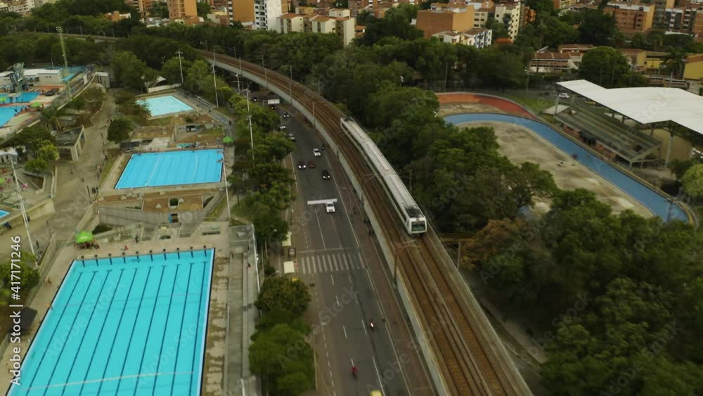 Aerial Tracking Shot of Subway Train Passing Swimming Pools in Medellin. Aerial Tracking Shot of Subway Train Passing Swimming Pools in Medellin.