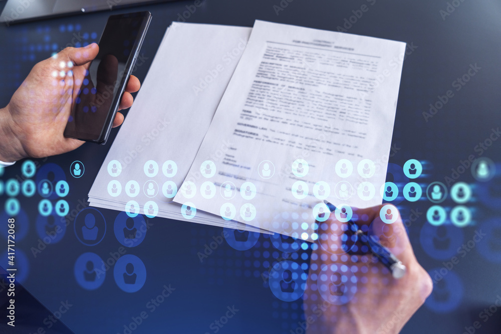 A potential employee in formal suit signing the contract to boost his career and gain new opportunities in personal growth. Concept of success. Hiring a new talented crew. Social media hologram icons A potential employee in formal suit signing the contract to boost his career and gain new opportunities in personal growth. Concept of success. Hiring a new talented crew. Social media hologram icons