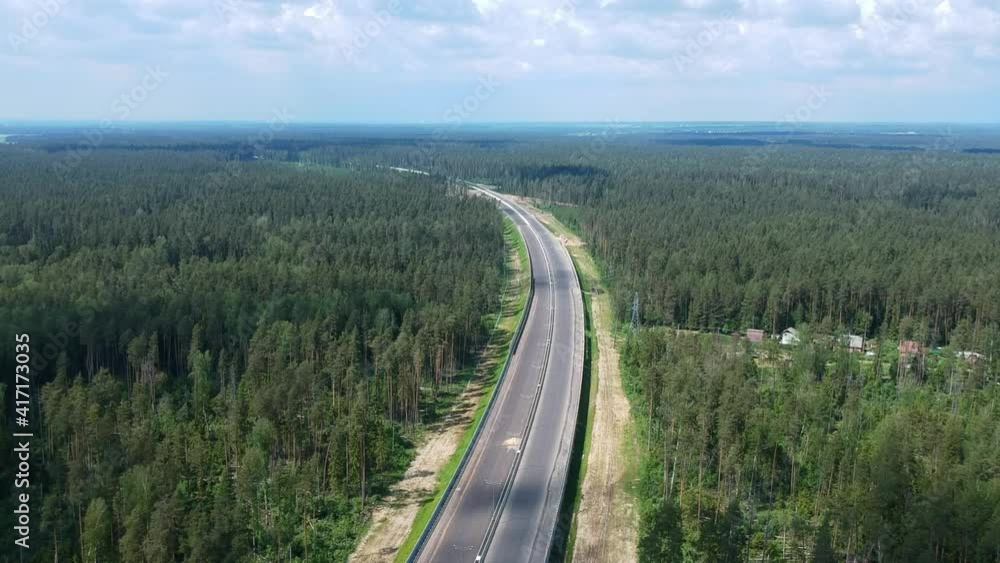 Construction of a high speed highway in the forest. Aerial video shooting from drone. Green trees. New asphalt pavement of the road. High quality FullHD footage Construction of a high speed highway in the forest. Aerial video shooting from drone. Green trees. New asphalt pavement of the road. High quality FullHD footage