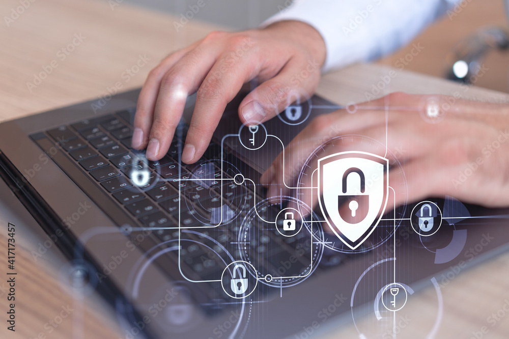 A programmer is typing a code on computer to protect a cyber security from hacker attacks and save clients confidential data. Padlock Hologram icons over the typing hands. Formal wear. A programmer is typing a code on computer to protect a cyber security from hacker attacks and save clients confidential data. Padlock Hologram icons over the typing hands. Formal wear.