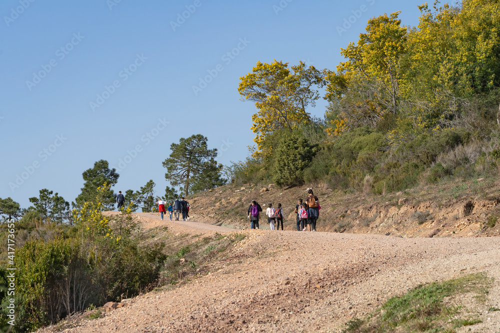 A group of people go hiking in the mountains of Theoule-sur-Mer on the Mediterranean coast of France. 