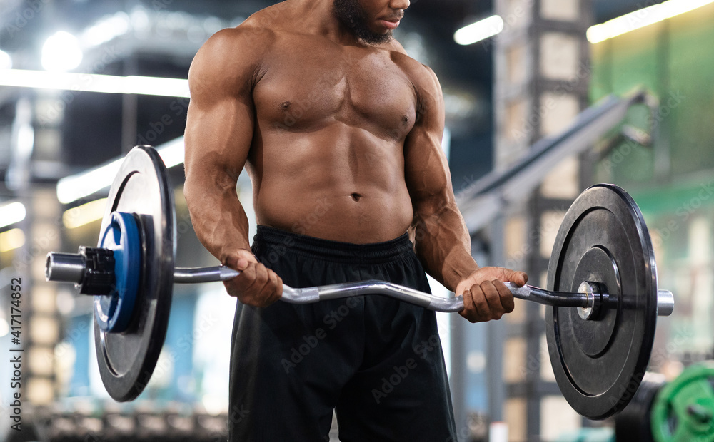 Cropped of black muscular guy bodybuilder lifting weights Cropped of black muscular guy bodybuilder lifting weights