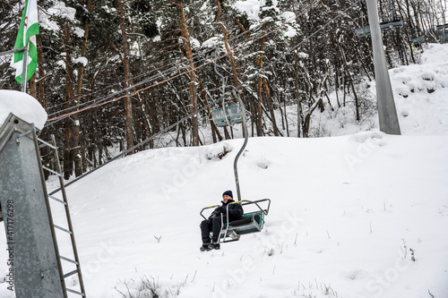 a man in a black jacket on a ski fan cooler in the mountains 