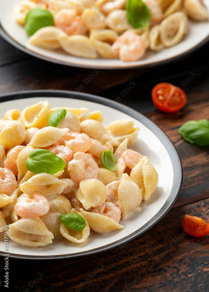 Italian conchiglie prawn, shrimp pasta in a creamy sauce on plate. Italian conchiglie prawn, shrimp pasta in a creamy sauce on plate.