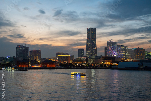 Yokohama in the evening hours with a view of Yokohama skyline with tourists boards crossing the bay © Stefan