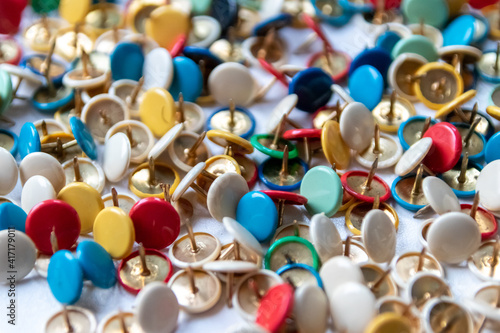 Bunch of many colorful thumbtacks as multi-color office supply metal pushpins circles in yellow, green, blue, red and white as design collection for business pins and school organization equipment