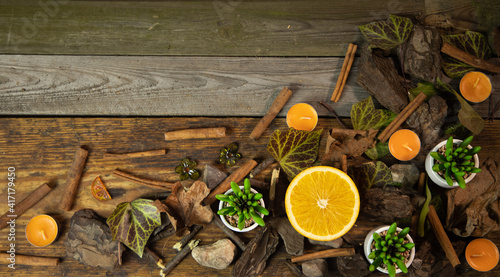 Tło z drewnianych desek wraz z dekoracją liście gałązki kamienie pomarańcz i laski cynamonu