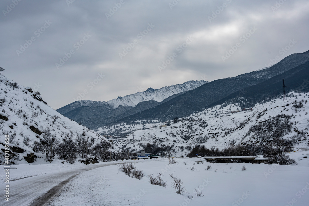 panoramic landscape of winter mountains, passes and snow-covered trees in the Caucasus 