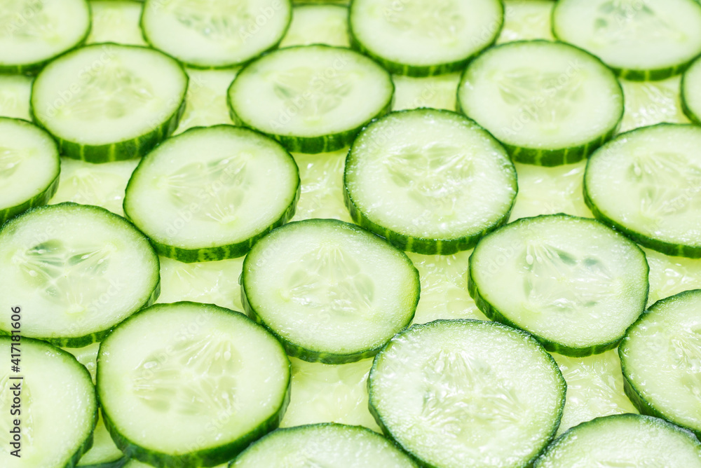 Fresh green slices of cucumber as background. Fresh green slices of cucumber as background.