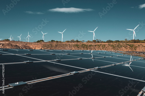 Wind farm and solar panels under a beautiful blue sky with a few clouds. Renewable energy generation for environmental conservation concept.  photo