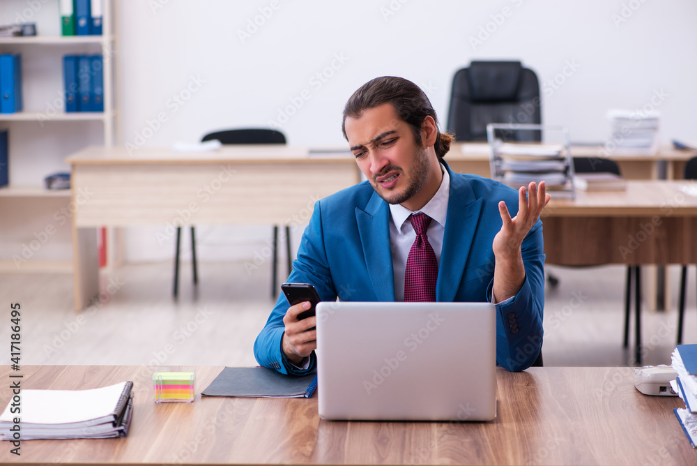 Young male employee working at workplace Young male employee working at workplace