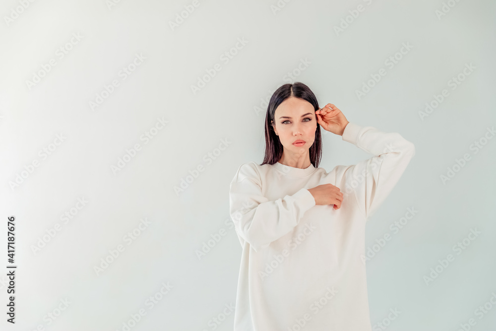 Mock-Up. portrait of a beautiful girl with black long hair in a hoody on a white background. the concept of sport Mock-Up. portrait of a beautiful girl with black long hair in a hoody on a white background. the concept of sport