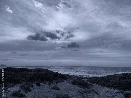 Sunset with beautiful cloudy skies among the sand dunes  Sardinia  Italy.