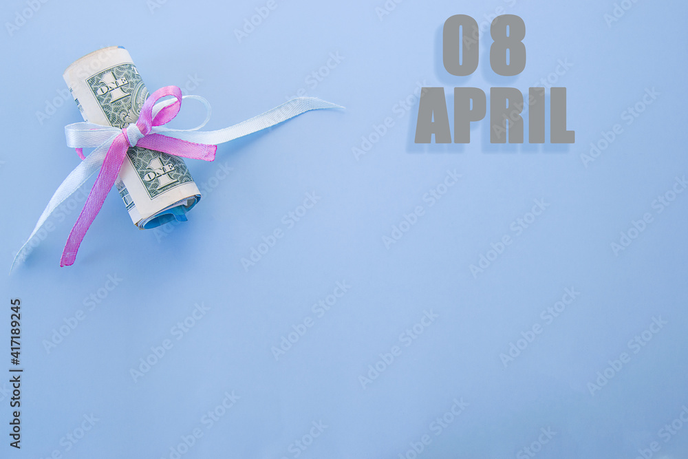 calendar date on blue background with rolled up dollar bills pinned by blue and pink ribbon with copy space. April 8 is the eighth day of the month calendar date on blue background with rolled up dollar bills pinned by blue and pink ribbon with copy space. April 8 is the eighth day of the month