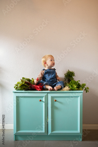 Photos Cute baby surrounded by organic vegetables