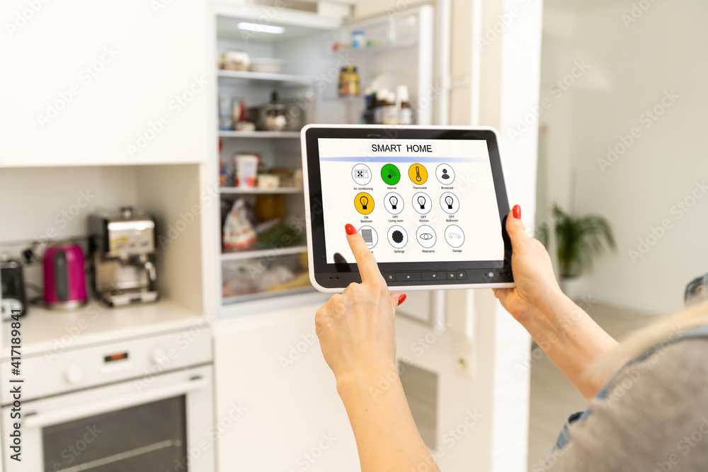 Online Supermarket Shopping Hands with computer tablet shopping cart icon in front of refrigerator Online Supermarket Shopping Hands with computer tablet shopping cart icon in front of refrigerator