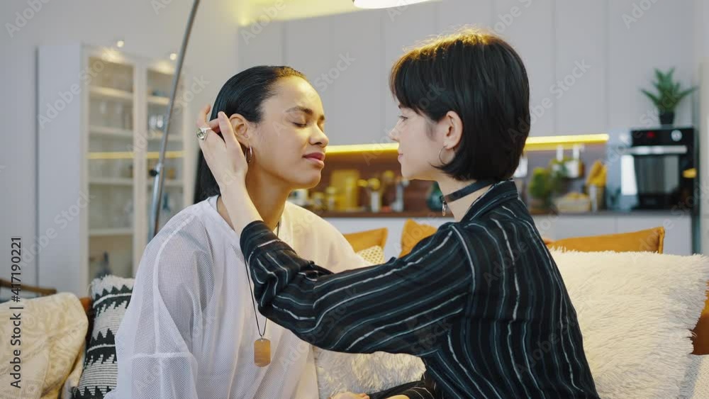 Happy same sex couple spend time together at home. Girl gently stroking her girlfriend, intimacy and care concept Happy same sex couple spend time together at home. Girl gently stroking her girlfriend, intimacy and care concept