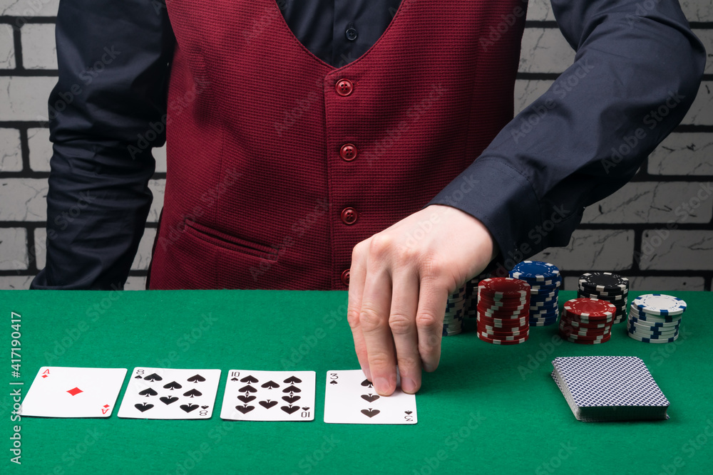 the dealer at the green poker table opens the cards the dealer at the green poker table opens the cards