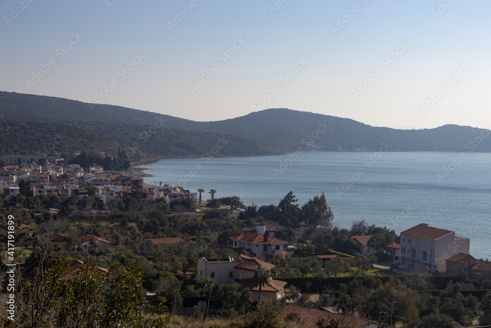 houses in a beautiful bay, beach, sea and palm trees and mountains in the background