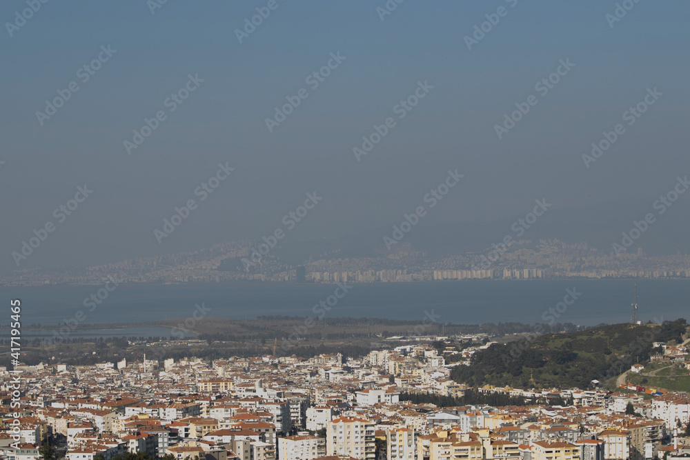 View of Houses, trees and grasses and Mediterranean sea . Fog on the other side of city.