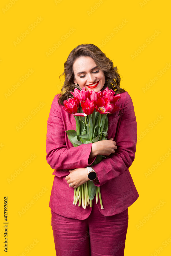 Portrait of happy woman in suit embracing bunch of pink tulips. Portrait of happy woman in suit embracing bunch of pink tulips.