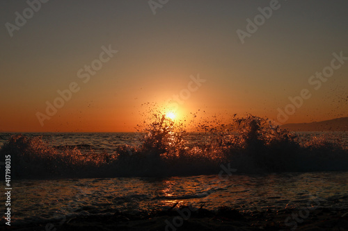 sunset over the sea and droplets of waves