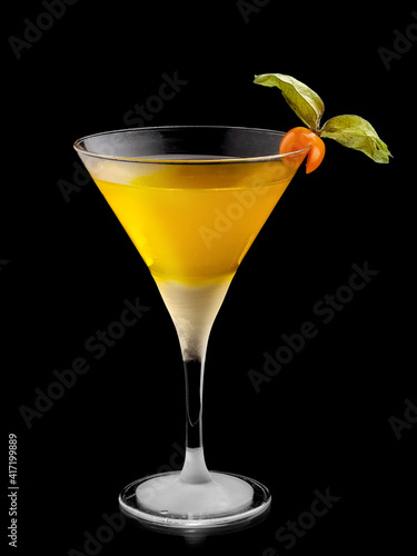 Frozen cocktail Maracuja in martini glass with a phyzalis decoration on black background