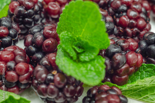 Closeup of a set of blackberries with mint, fresh and ripe forest fruits