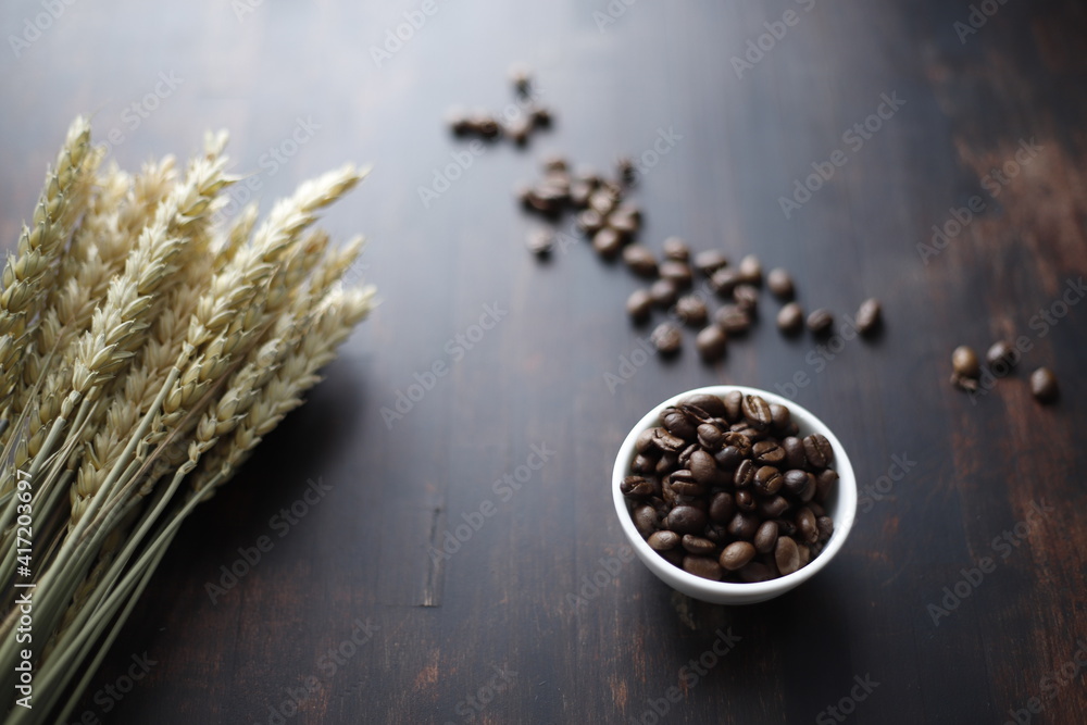 Obraz premium Kawa w ziarnach na stole brązowym drewnianym