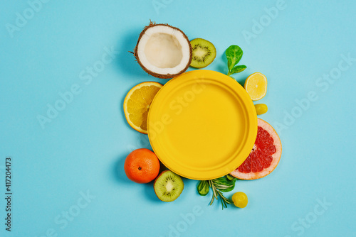 Fototapeta Naklejka Na Ścianę i Meble -  Composition of citrus fruit, orange and lemon, coconut, kiwi on cyan background