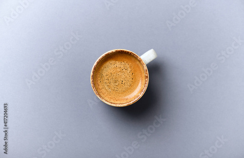 Cup of coffee on gray background. Top view.