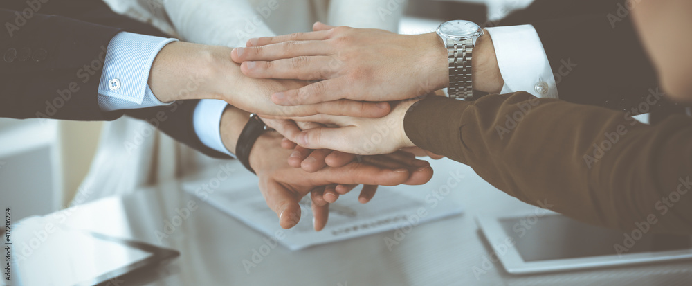 Business people group showing teamwork and joining hands or giving five in modern office. Unknown businessman and women making circle with their hands