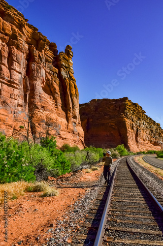 Railroad at the bottom of a canyon next to Layered Geological Formations of Red Rocks.