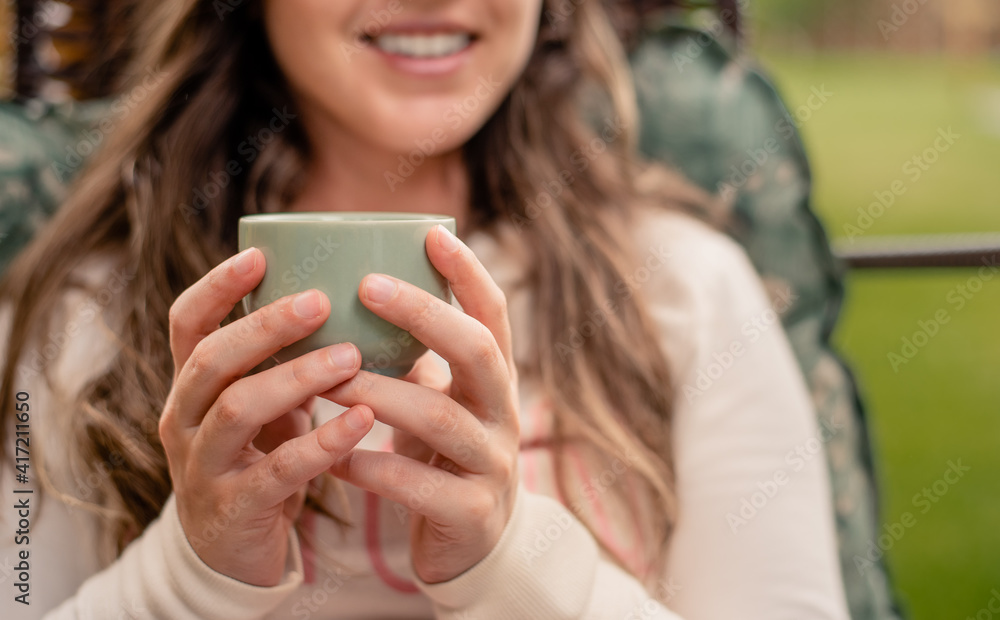 Woman holding a cup of coffee by the morning Woman holding a cup of coffee by the morning