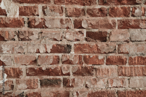 Red brick wall with cracked and damaged surface, in the middle a bright brick wall like a frame, background for a template, no person