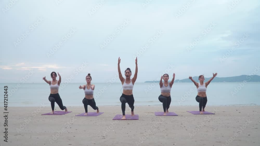 B roll of Athletic group of women practicing yoga position at sunrise beach. Fitness training outdoor stretching body at morning. Morning yoga practice soft sunlight on the beach. B roll of Athletic group of women practicing yoga position at sunrise beach. Fitness training outdoor stretching body at morning. Morning yoga practice soft sunlight on the beach.