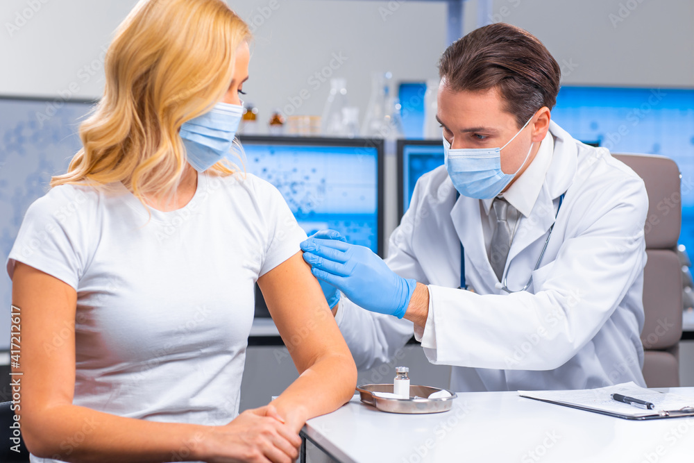 Professional doctor makes a coronavirus vaccine using a syringe and hypodermic needle. Professional medical worker and patient at the hospital office. Vaccination and safety. Professional doctor makes a coronavirus vaccine using a syringe and hypodermic needle. Professional medical worker and patient at the hospital office. Vaccination and safety.