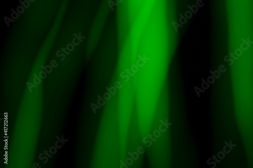 Green abstract background - lines and streaks of light. Blurred, irregular light elements on black background. Green fanciful 3d patterns.