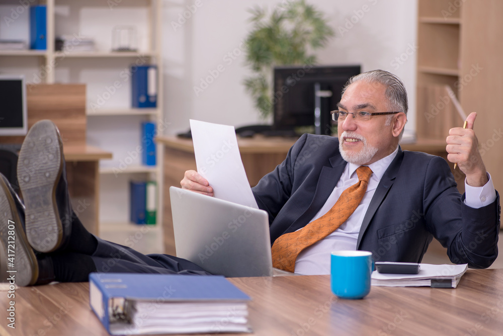 Old male employee working in the office Old male employee working in the office