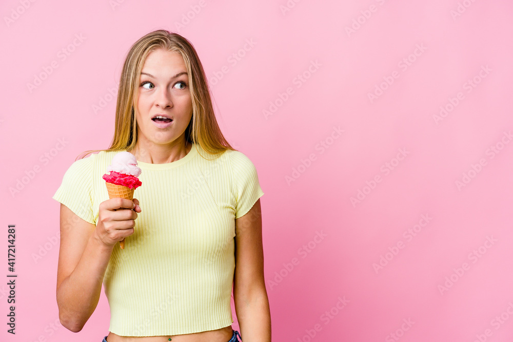 Young russian woman eating an ice cream isolated being shocked because of something she has seen. Young russian woman eating an ice cream isolated being shocked because of something she has seen.