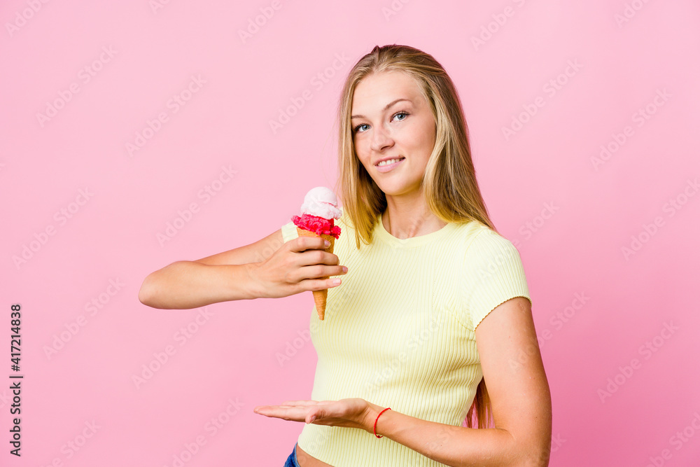 Young russian woman eating an ice cream isolated holding something with both hands, product presentation. Young russian woman eating an ice cream isolated holding something with both hands, product presentation.
