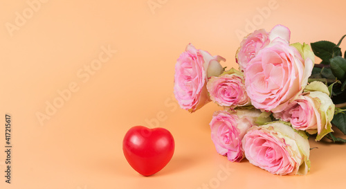 A bouquet of gradient pink roses and a red heart on a yellow background. Holiday greeting card