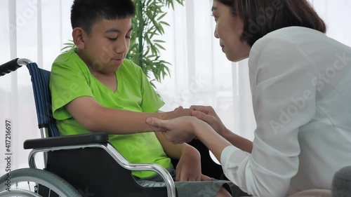 Mother holding hands boy with disability on wheelchair at home. Supportive, Encouragement, Care, Coexistence Slow motion shot