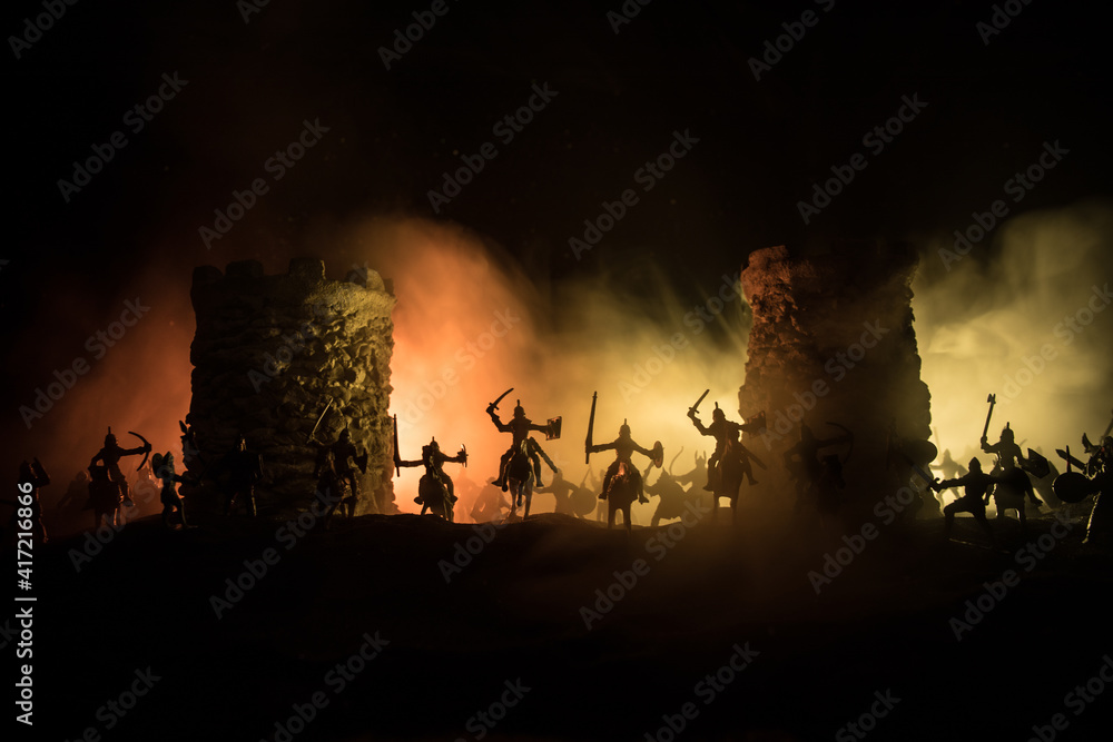 Fototapeta premium Medieval battle scene. Silhouettes of figures as separate objects, fight between warriors at night. Creative artwork decoration. Foggy background.