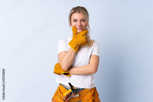 Fotografie Electrician woman over isolated blue background laughing