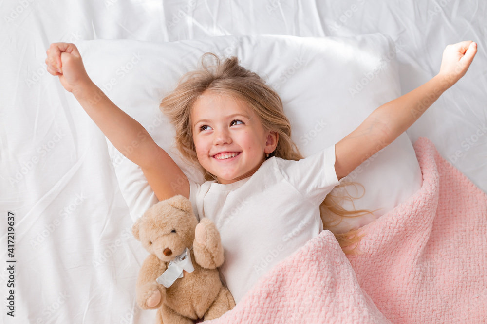little blonde girl sleeping in bed hugging a teddy bear under a pink knitted blanket, space for text little blonde girl sleeping in bed hugging a teddy bear under a pink knitted blanket, space for text