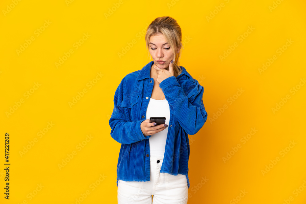 Young Russian woman isolated on yellow background thinking and sending a message Young Russian woman isolated on yellow background thinking and sending a message